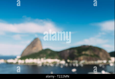 Volutamente sfuocate vista astratta di Sugarloaf Mountain e a Rio de Janeiro in Brasile skyline riflettendo su Botafogo Bay. Foto Stock