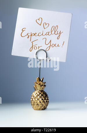 Ananas titolare di carta con una iscrizione - specialmente per voi, su un blu sfondo colorato Foto Stock