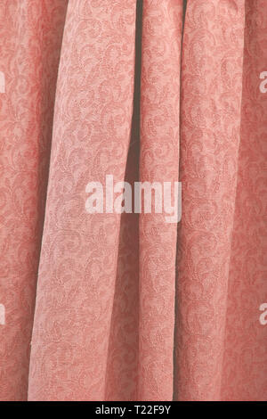 Bella piegato damasco tessuto di cotone intessuto texture di sfondo verticale in tonalità colore trend coralli viventi. Foto Stock