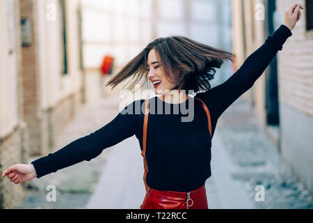 Felice giovane donna ballare in strada Foto Stock