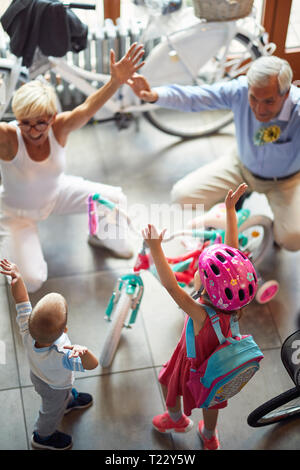 Nonni felici con poco nipoti acquisto nuova bicicletta Foto Stock