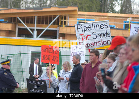 Manifestanti azienda cartelli in un evento mediatico in Maple Ridge, B. C. Foto Stock