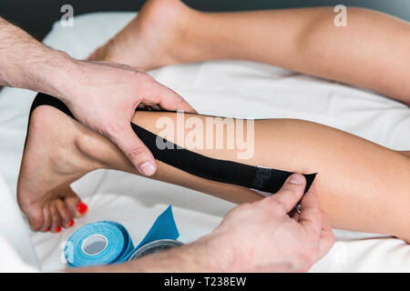 Terapista immissione kinesio taping a piedi. Foto Stock