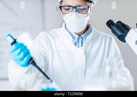 La ricerca scientifica sulla vita. Tecnico utilizzando micropipetta. Foto Stock