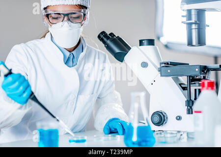 La ricerca scientifica sulla vita. Tecnico utilizzando micropipetta. Foto Stock