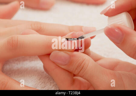L'applicazione di rivestimento di base di un unghia alla manicure. Foto Stock