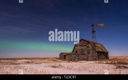 Luci del nord oltre il fienile vintage, scomparti e mulino a vento in Saskatchewan Foto Stock