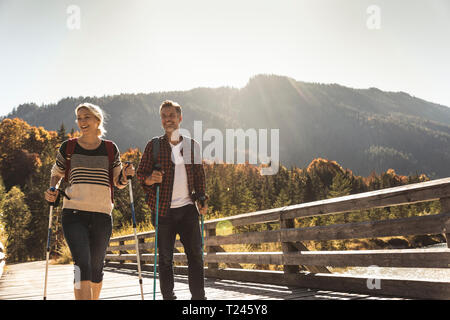 Austria, Alpi coppia felice su una escursione attraversando un ponte Foto Stock
