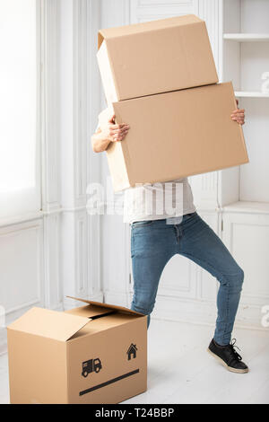Irriconoscibile uomo che porta le scatole di cartone nella nuova casa Foto Stock