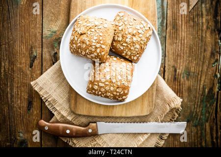 Tre tutto pasto panini con fiocchi di avena su piastra Foto Stock