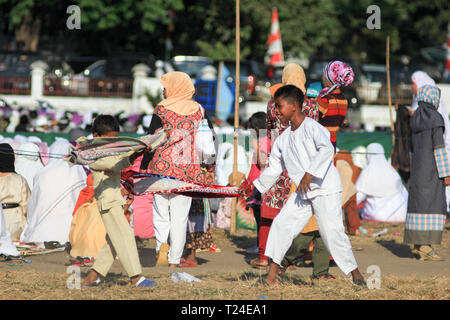 MAUMERE,Flores/INDONESIA-Agosto 31 2011: Maumere i bambini giocare sarong dopo aver pregato sul campo. Hanno un aspetto felice Foto Stock