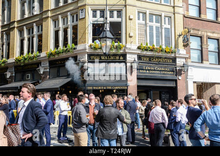 Le persone in un momento di relax a ora di pranzo fuori il Tricheco e il Legnaiuolo, pub nella città di Londra, monumento Street, London EC3, Regno Unito Foto Stock