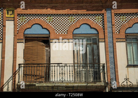 Porte a balcone sulla facciata del palazzo in stile eclettico con piastrelle di ceramica a Merida. La città conserva molti edifici della Roma antica in Spagna. Foto Stock