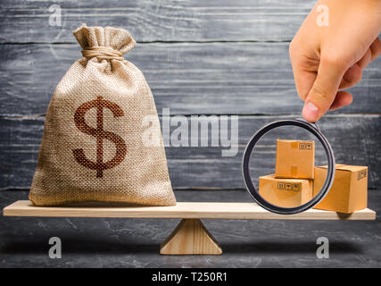 Lente di ingrandimento è guardando il mazzetto di scatole. sacchetto di denaro sulle scale. Commercio concettuale equilibrio tra paesi e sindacati, commercio e exc Foto Stock