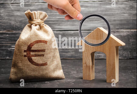 Lente di ingrandimento è guardando la casa con una grande porta ed una borsa con denaro euro. Le imposte sul reddito a noleggio. Case in costruzione. affittare o purchaseConcep Foto Stock