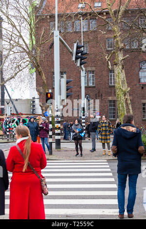 Persone in attesa per la luce verde sul passaggio pedonale Foto Stock