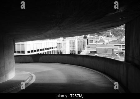 Vista attraverso una cornice architettonica di alcuni edifici a Lugano (Svizzera) da un parcheggio - foto in bianco e nero Foto Stock