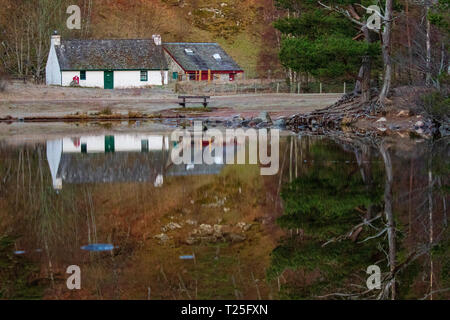 Loch un Eilein e Visitor Center su una tranquilla mattina di primavera con la riflessione sul loch sul Rothiemurchus Estate, Aviemore, Scozia Foto Stock