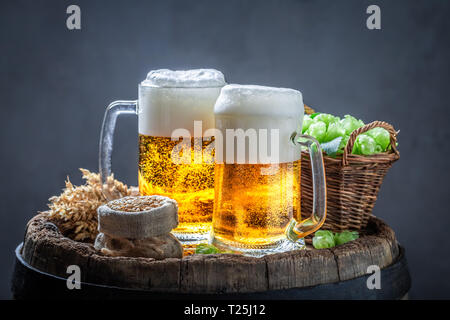 Due oro pinte di birra sul vecchio Barile di legno Foto Stock