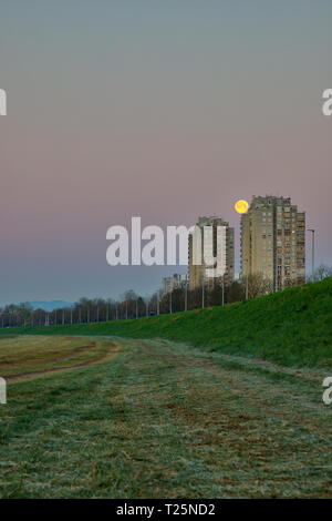 Impostazione della luna in basso al mattino dietro gli edifici in Zagreb Foto Stock