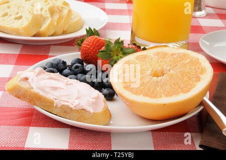 Pompelmo, bacche e toast con fragola crema di formaggio per la prima colazione Foto Stock