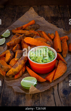 La patata dolce cunei con avocado dip Foto Stock