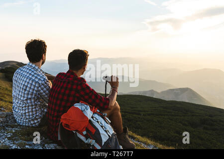 L'Italia, Monte Nerone due escursionisti sulla cima di una montagna godendo la vista al tramonto Foto Stock