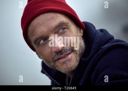 Ritratto di barbuto uomo maturo che indossa cappuccio rosso all'aperto Foto Stock