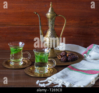 Iftar e Suhoor Ramadan concetto ,mentha tè in bicchieri di vetro e le date su sfondo di legno con una vecchia teiera Foto Stock
