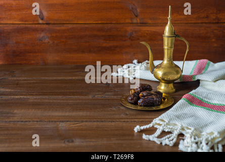 Il Ramadan preparazione alimentare, teiera con date, iftar cibo su sfondo di legno con spazio di copia Foto Stock