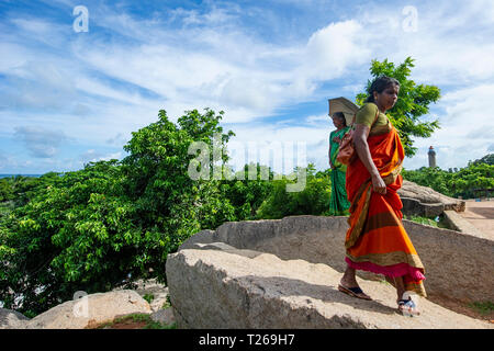 Eleganza presso i monumenti di Mahabalipuram vicino a Chennai, India come donne passeggiata in campagna, proteggersi dal sole con un ombrellone Foto Stock