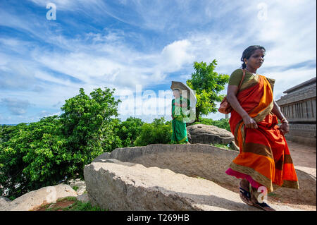 Eleganza presso i monumenti di Mahabalipuram vicino a Chennai, India come donne passeggiata in campagna, proteggersi dal sole con un ombrellone Foto Stock