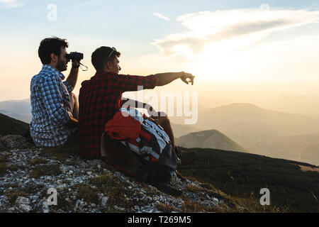 L'Italia, Monte Nerone due escursionisti sulla cima di una montagna godendo la vista al tramonto Foto Stock