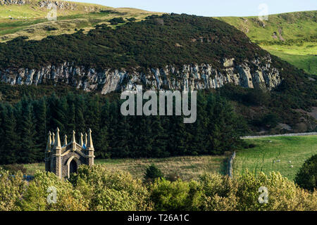 Scenario di frontiera in Cheviot colline dove si unisce la Scozia in Inghilterra. Kirk Yetholm (fine del The Pennine Way) chiesa con scogliere di cava al di là. Foto Stock