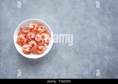 Gamberi, gamberetti nella ciotola, vista dall'alto, copia dello spazio. Piatti a base di frutti di mare freschi ingredienti - Code di gamberi pronti per la cottura. Gamberi bolliti. Foto Stock