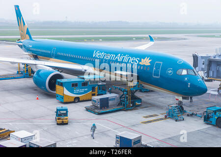 Vietnam Airlines aeromobili aria di carico ai contenitori di carico prima del volo all'aeroporto internazionale di Noi Bai ad Hanoi, Vietnam. Foto Stock