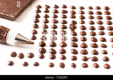 Concetto di cibo facendo cioccolato artigianale di trucioli per pasticceria su sfondo bianco Foto Stock