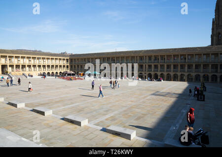 La piazza centrale e area del quadrangolo del pezzo Hall. Sunny / sun & blue sky. Halifax, West Yorkshire, Regno Unito. La parete nord è illuminata dalla luce del sole; la parete est è in ombra. (106) Foto Stock