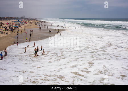 Una soleggiata giornata estiva su Huntington Beach offre una varietà di persone fuori per divertirsi e rilassarsi in molti diversi hobby di impegno e di attività. Foto Stock