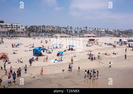 Una soleggiata giornata estiva su Huntington Beach offre una varietà di persone fuori per divertirsi e rilassarsi in molti diversi hobby di impegno e di attività. Foto Stock