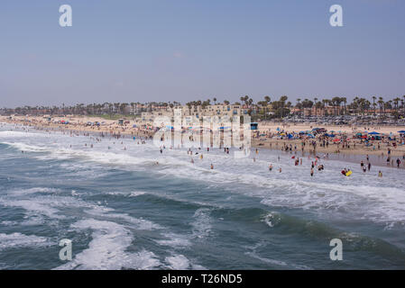 Una soleggiata giornata estiva su Huntington Beach offre una varietà di persone fuori per divertirsi e rilassarsi in molti diversi hobby di impegno e di attività. Foto Stock