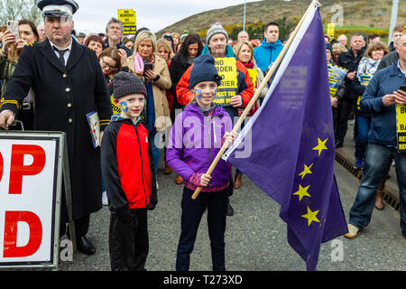 Carrickcarnon, UK. Il 30 marzo 2019. Aoife McGenity tenendo una bandiera UE con suo fratello Paraic che facevano parte della grande folla di persone che hanno preso parte a una protesta Brexit a Carrickcarnon che è uno dei principali punti di attraversamento della frontiera britannica in Irlanda Credito: Bonzo Alamy/Live News Foto Stock