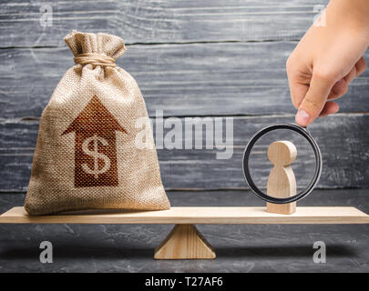 Lente di ingrandimento è guardando un sacco di denaro con freccia su e uomo figurina su scale. Criteri e requisiti per aumentare il lavoro di uno specialista Foto Stock