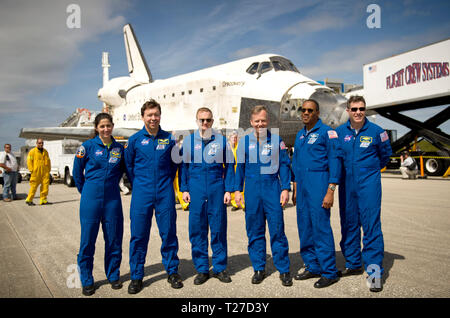 Gli astronauti della NASA e STS-133 missione membri di equipaggio, da sinistra, gli specialisti di missione Nicole Stott, Michael Barratt, pilota Eric Boe, Comandante Steve Lindsey, gli specialisti di missione Alvin Drew, e Steve Bowen posano per una foto davanti alla navetta spaziale Discovery dopo aver atterrato, Mercoledì, 9 marzo 2011, presso il Kennedy Space Center di Cape Canaveral, in Florida, il completamento del rilevamento 39th e volo finale. Foto Stock