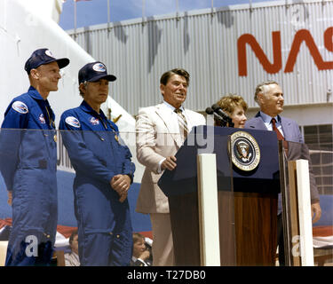 Il Presidente Ronald Reagan parla a una folla di oltre 45.000 persone alla NASA Dryden Flight Research Center dopo lo sbarco di STS-4 il 4 luglio 1982. A destra del Presidente sono la Signora Reagan e amministratore della NASA James M. Beggs. A sinistra sono STS-4 Columbia astronauti Thomas K. Mattingly e Henry W. Hartsfield, Jr. prototipo Space Shuttle Enterprise è in background. Foto Stock