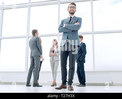 Vista dal basso.imprenditore di successo in piedi in un luminoso ufficio. Foto Stock