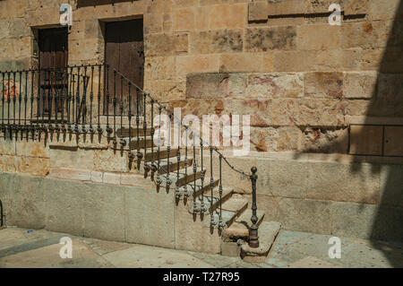 Vecchio edificio sul vicolo e scala in pietra con cancellata in ferro battuto a Salamanca. Con edifici medievali è anche una città universitaria dalla Spagna. Foto Stock