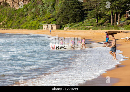 In legno tradizionali barca surf con femmina womens rowing team,Newport Beach di Sydney Foto Stock