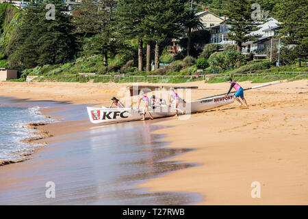 In legno tradizionali barca surf con femmina womens rowing team,Newport Beach di Sydney Foto Stock