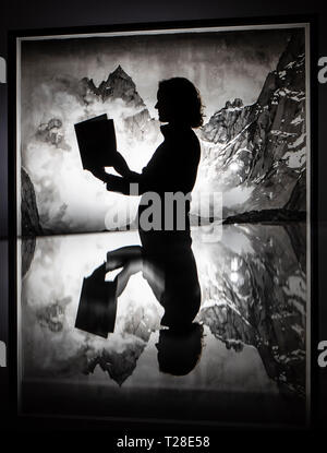 Assistente galleria Emma Woolfrey legge un programma espositivo come ella si è riflessa in una vetrina di fronte a un lavoro di artista Emma Stibbon, parte del Ruskin, Turner e la tempesta Cloud: acquerelli e disegni mostra che ha aperto questo weekend al York Galleria d'arte. Foto Stock